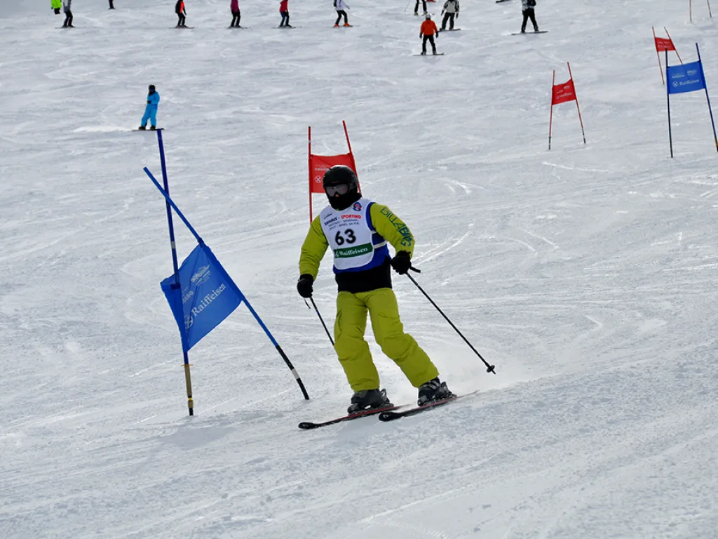 Skifahrer in gelber Hose auf der Rennstrecke.